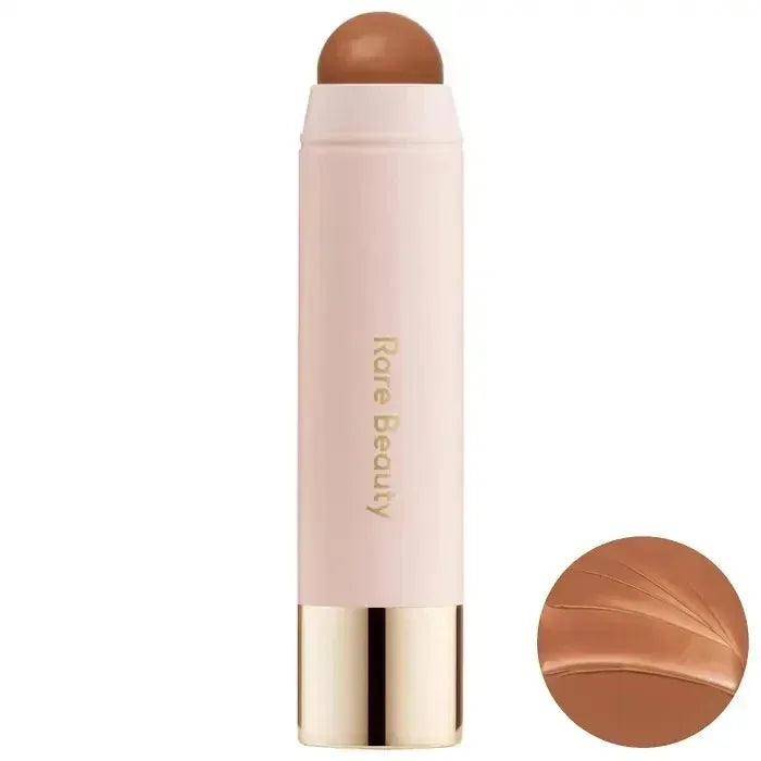 A tube of liquid bronzer contour foundation stick with a pink casing and a bronze product tip.