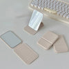 A portable makeup mirror with a light-colored PU leather casing and a reflective surface is shown next to a keyboard.