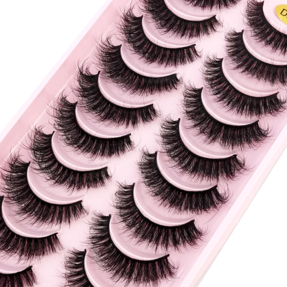 Plateau en plastique rose contenant plusieurs paires de faux cils de renard noirs.