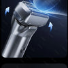 Close-up of a silver portable electric shaver with a vibrating head and body, demonstrating its high-speed low-noise motor te