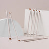 A set of precision angled eyeliner and eyebrow makeup brushes with light wood handles displayed on a white background.