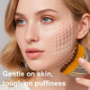 A woman applies a facial massage using a stainless steel gua sha tool on her cheek, demonstrating gentle skin treatment.