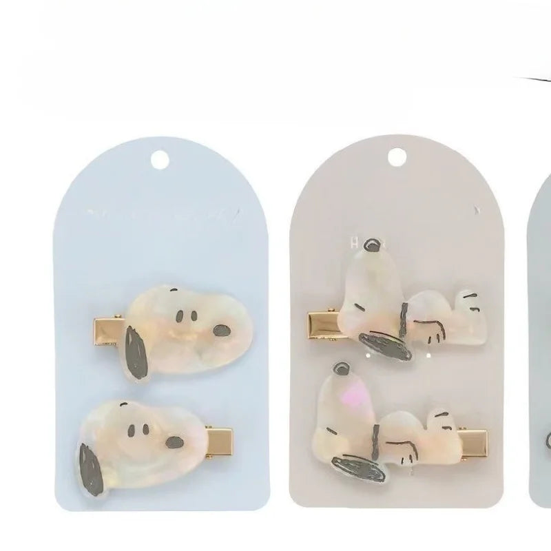 A set of Snoopy cartoon hair clips featuring white and gray designs on a clear background.