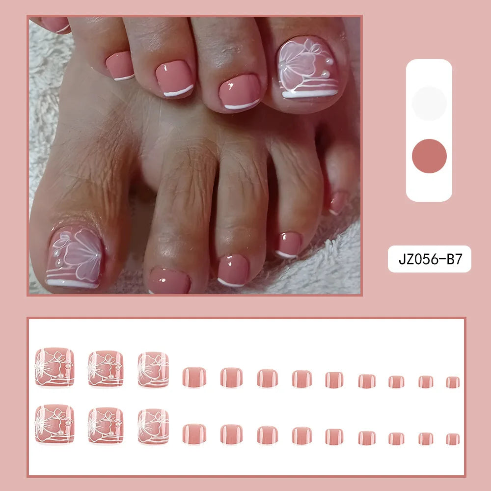 Set wiederverwendbare falsche Zehennägel mit zartem weißen Blumenmuster in verschiedenen Rosé- und Nude-Tönen.