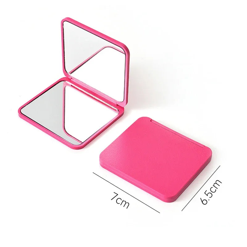A pink portable makeup mirror with a hinged, double-sided design shown open and closed.