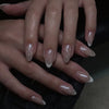 Close-up of a hand displaying red and pink striped press-on nails with an almond shape