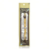 A traditional wooden miswak toothbrush packaged in a clear plastic pouch with decorative elements.