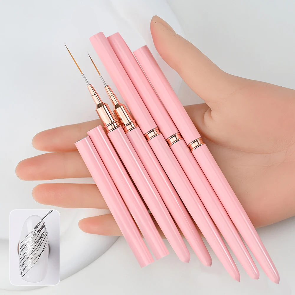 A hand holds a set of pink nail art liner brushes with ultra-fine tips.