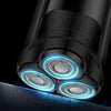 Close-up of an intelligent rechargeable electric shaver with glowing blue light on a dark background.