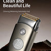 A close-up of a silver electric foil shaver with a textured head, shown against a dark background.