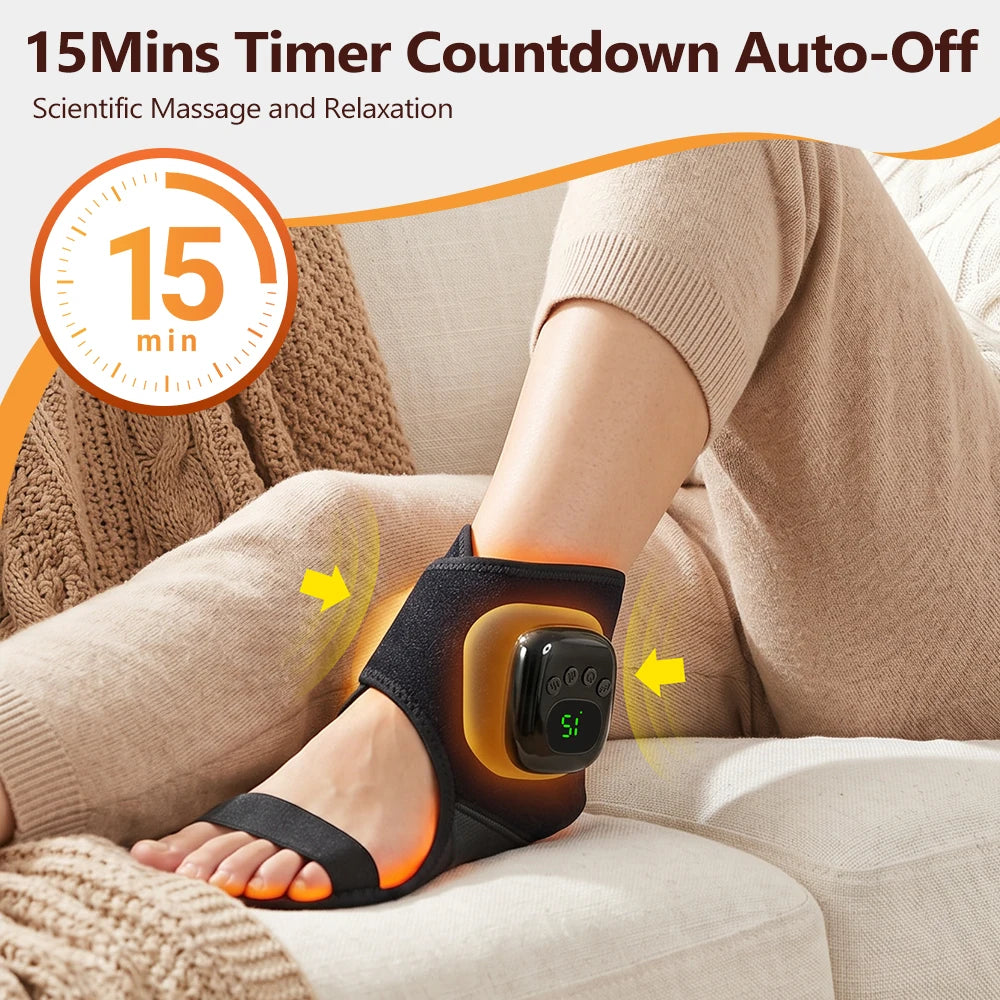 A person is using a black heated ankle massager device on their foot while relaxing indoors.