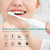 A close-up of a woman using a white sonic electric toothbrush for oral cleaning.