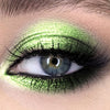 Primer plano de un ojo con sombra metálica brillante y dorada verde glitter.