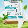 A white 2-in-1 multifunctional floss stick is shown with a green tip, packaged in a teal box, against a blurred green outdoor