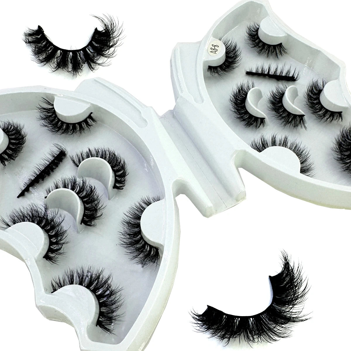 A white cosmetic case containing natural mink striped false eyelash extensions.