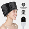 A woman is wearing a black electric hair steamer cap with adjustable temperature and timer settings.