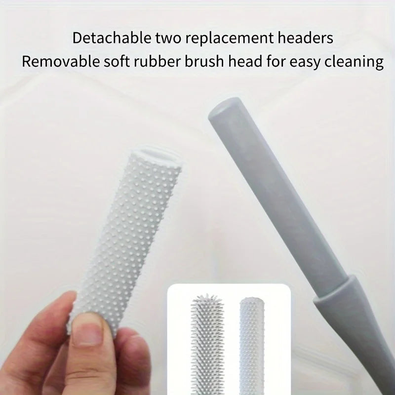 A hand holds a long-handled manual foot scrubber with detachable replacement heads for cleaning.