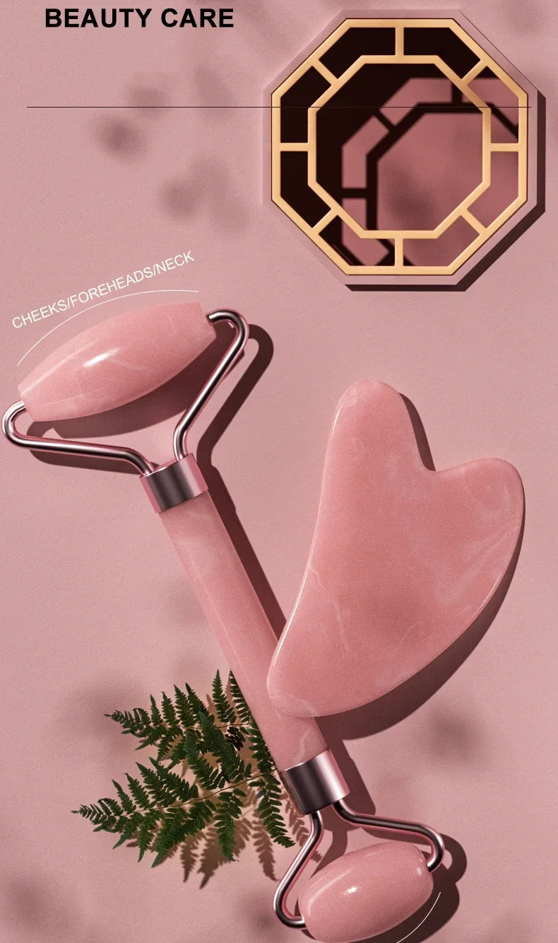 A pink jade gua sha tool is shown next to a hexagonal wooden mold and some green fern leaves.