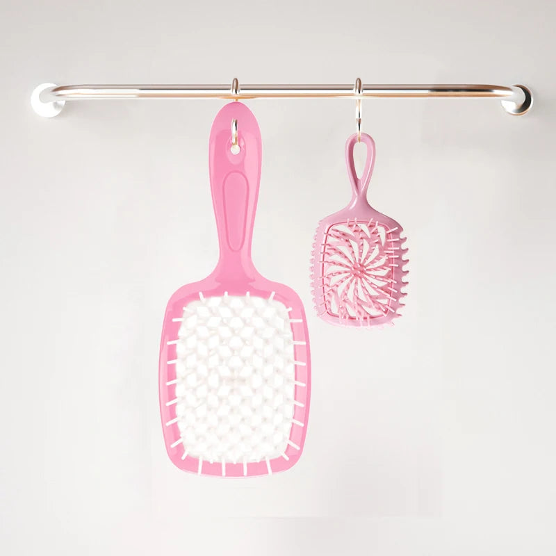 Pink detangling hair comb hanging on a metal bar