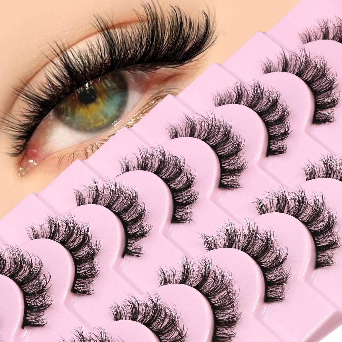 A close-up of a pink lash tray with black wispy cat eye false mink eyelashes displayed on the surface.