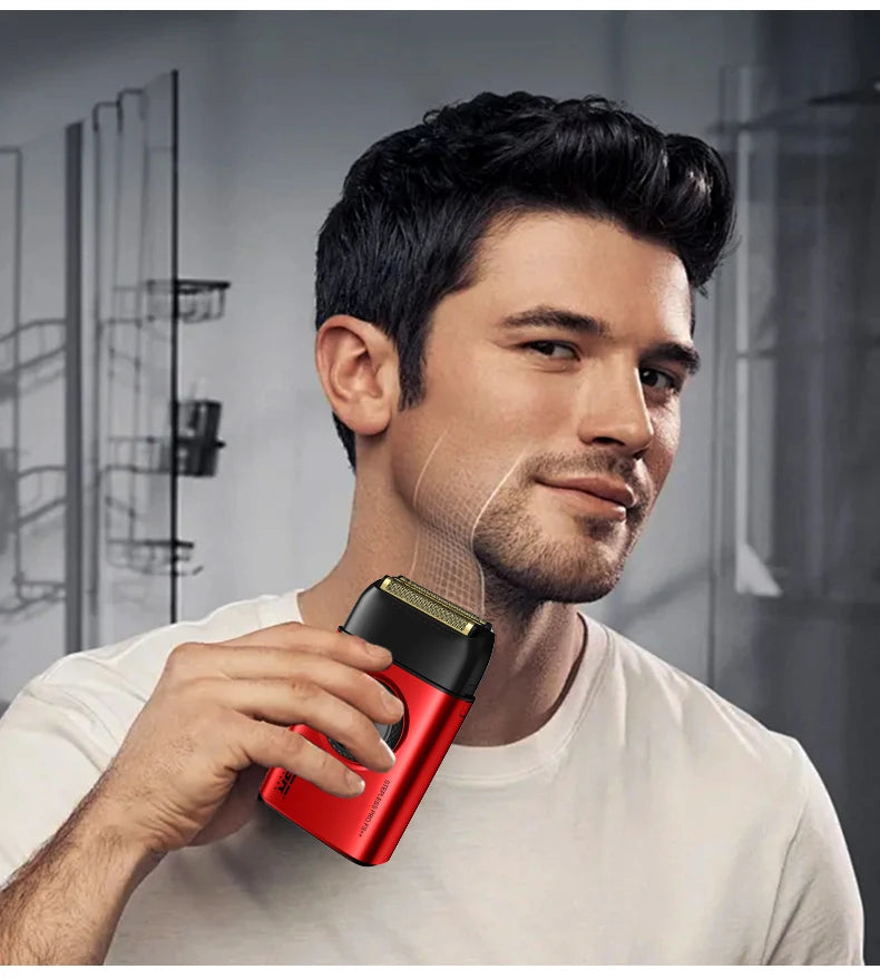 A man holds a red electric beard trimmer against his face in a modern indoor setting.
