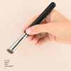 A hand holds a black and silver professional makeup brush set for foundation and concealer application.