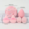 Un set de poudre de couleur rose, comprenant une grande boule duveteuse et plusieurs formes coniques.