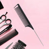 A collection of black professional rat tail combs and detangling brushes arranged on a pink background.