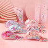 Un ensemble de peignes pour cheveux d'animaux colorés et pailletés pour enfants et adultes, présentés sur un fond rose.