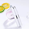 Flacon d'eau de parfum argenté à côté d'une tranche de citron jaune et d'un quartier de lime.