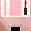 A portable pink makeup mirror is shown inside a clear plastic case with other cosmetic items.