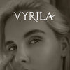 Close-up portrait of a woman with wispy eyelashes and the word VYRILA visible above her eyes.