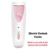 A white electric eyelash curler device with a pink interior and a green indicator light.