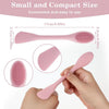 A hand is holding a pink double-headed silicone face cleansing brush, showing its size and texture.