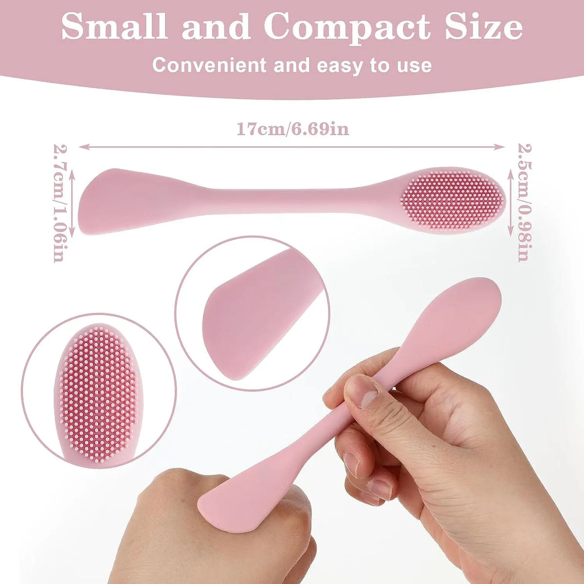 A hand is holding a pink double-headed silicone face cleansing brush, showing its size and texture.