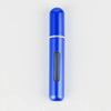 A sleek, cylindrical blue portable refillable perfume bottle with a silver band and a black dispensing mechanism.