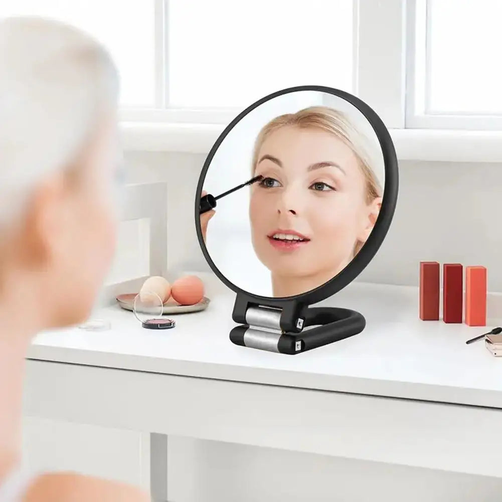 Une femme utilise un miroir de voyage à double face pour examiner son visage.