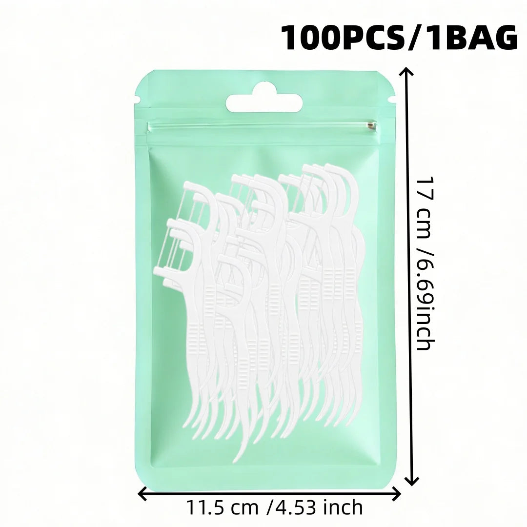 A package containing 100 reusable white dental floss picks in a light green pouch.