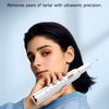 A woman holds a white smart ultrasonic tooth cleaner device against her face.