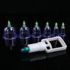 Un kit professionnel de vacuum cupping blanc avec plusieurs tasses et buses en verre, exposé sur une surface noire.
