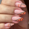 Close-up of a hand displaying press-on false nails with orange and black leopard print accents on a nude base.