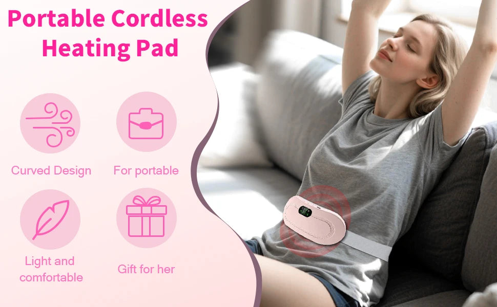 A woman is using a portable cordless heating pad massage belt on her torso while relaxing on a couch.