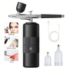 A black mini air compressor tool with a spray nozzle and various accessories for nail art application.