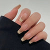 A hand displaying white French style coffin shaped press-on nails on a dark sleeve.