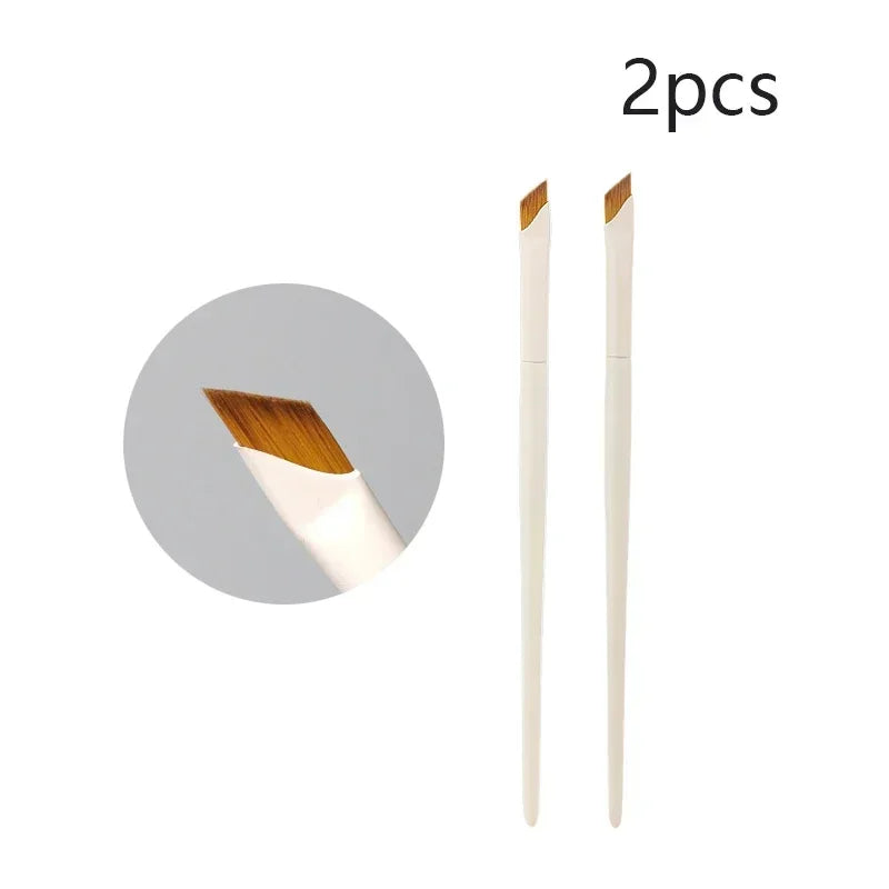 A set of two precision eyeliner application brushes shown next to a circular background.