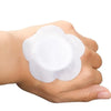 A hand holds a white disposable castor oil adhesive belly button patch.