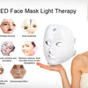 A woman applying a white LED face mask for light therapy, showing various skin benefits.