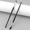 A pair of black and silver angled makeup brushes resting on a white cylindrical surface.