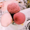 A set of pink and reddish-pink nail art dust brushes with fluffy tips displayed on a white surface.