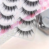 Five pairs of natural cat eye and C-roll strip false eyelashes displayed on a clear plastic sheet.